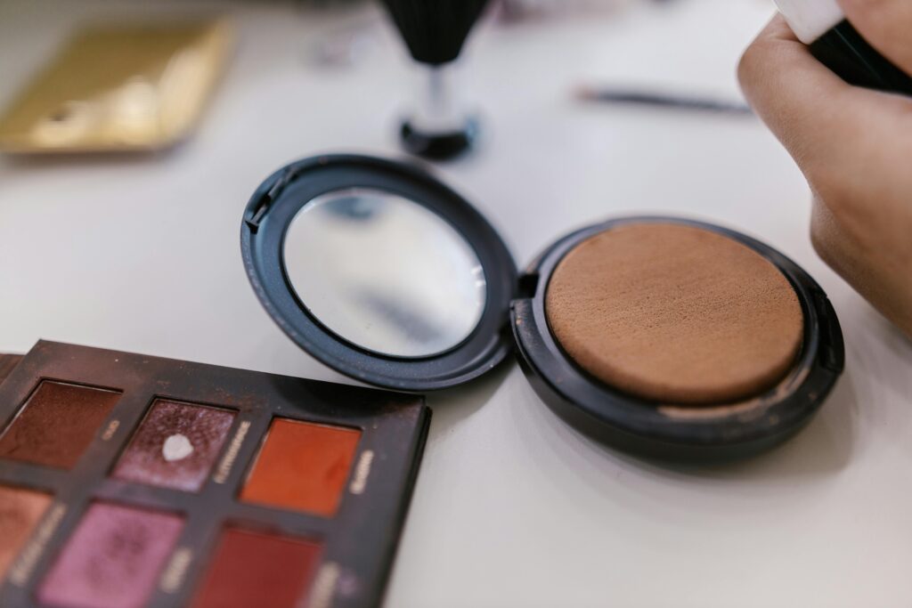 Detailed shot of makeup palette and compact powder on a table, perfect for beauty related content.