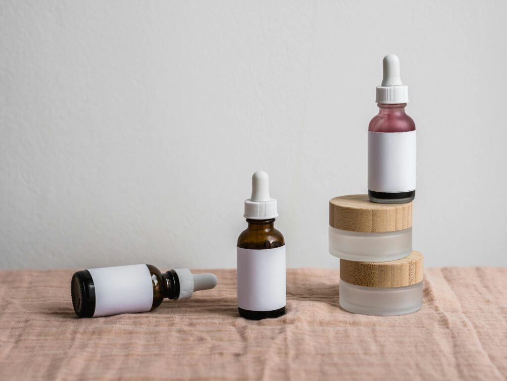 Minimalist display of assorted dropper bottles with blank labels on linen surface.
